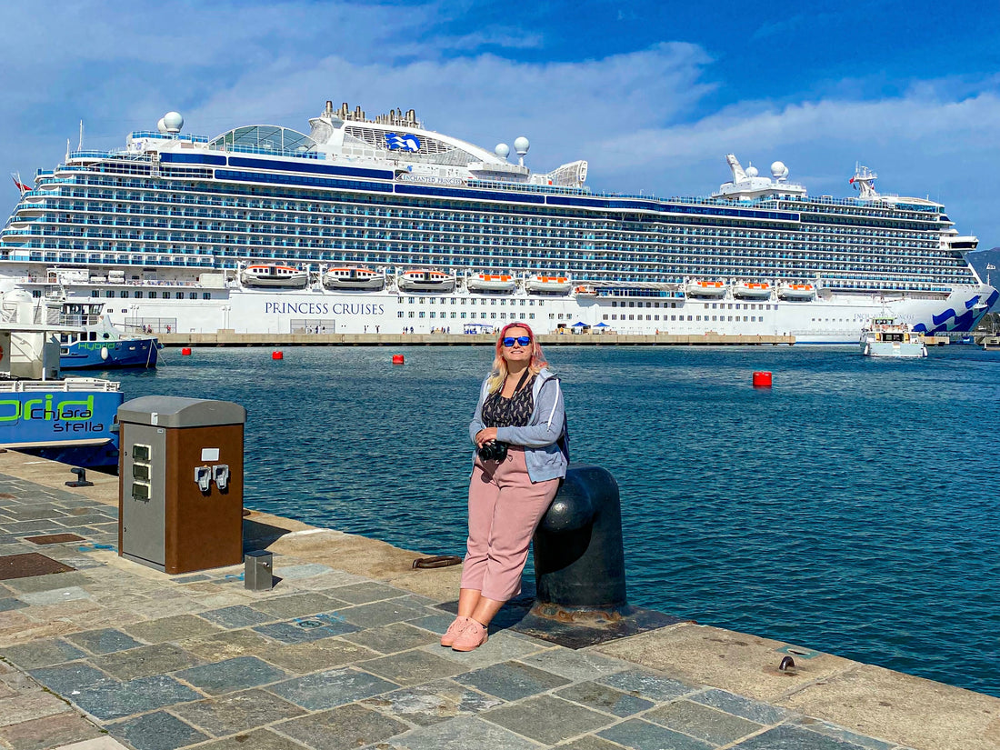 Blonde woman sat at the port of Ajaccio in front of the Enchanted Princess cruise ship